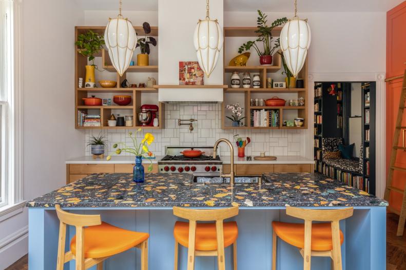 Light blue kitchen island with black and yellow terrazzo countertop 