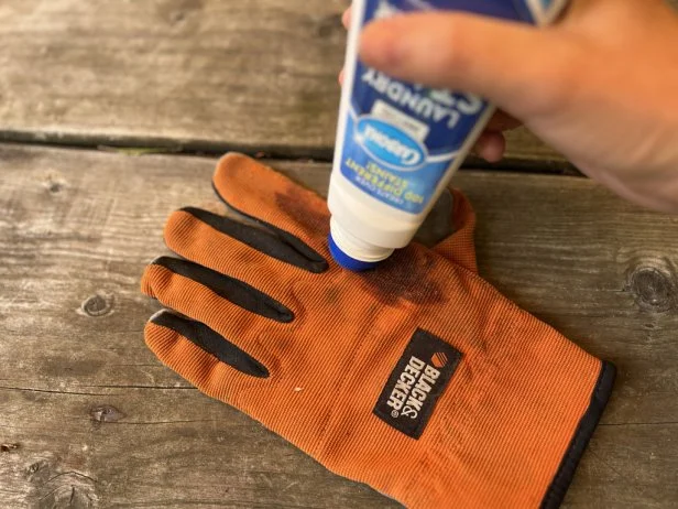 Cleaning dirty Black & Decker gardening gloves with Carbona Laundry Stain remover.