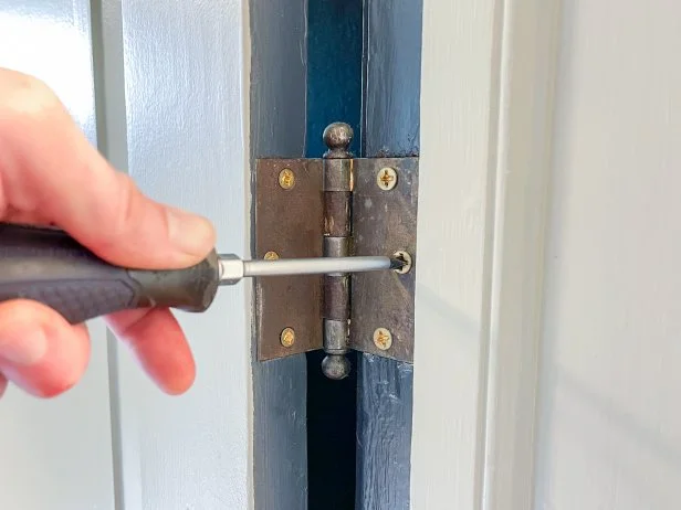 Before performing any other repair step to fix your door that won't latch, check all hinge screws to ensure they're tight. 