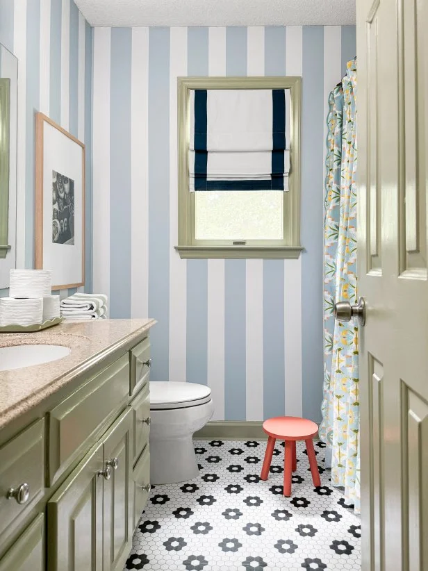 HGTV Magazine presents this kid's bathroom makeover with striped walls and penny tile decals on the floor.