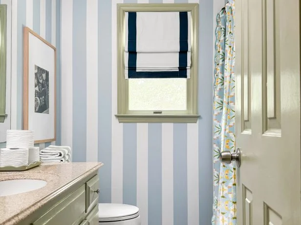 Bathroom With Blue Striped Walls and a Penny Tile Floor