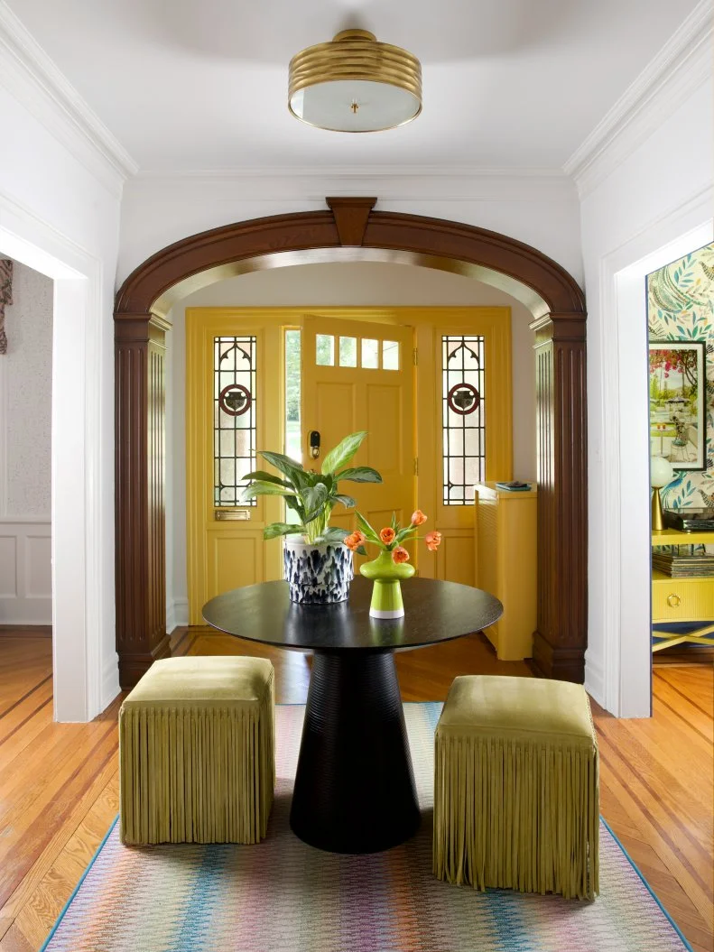 Colorful Entry With a Yellow Door and Wood Trim