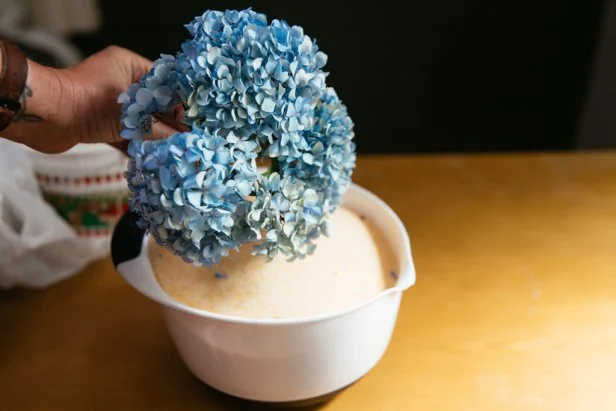 An editor at HGTV shows a hydrangea dried with silica powder