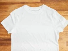 A white t-shirt on a wood table.