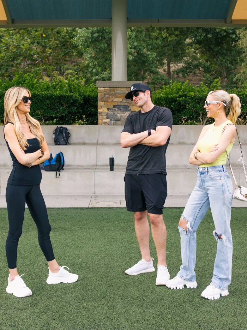 Christina Haack, Tarek El Moussa and Heather El Moussa on the soccer field looking away from camera, as seen on The Flip Off, Season 1.