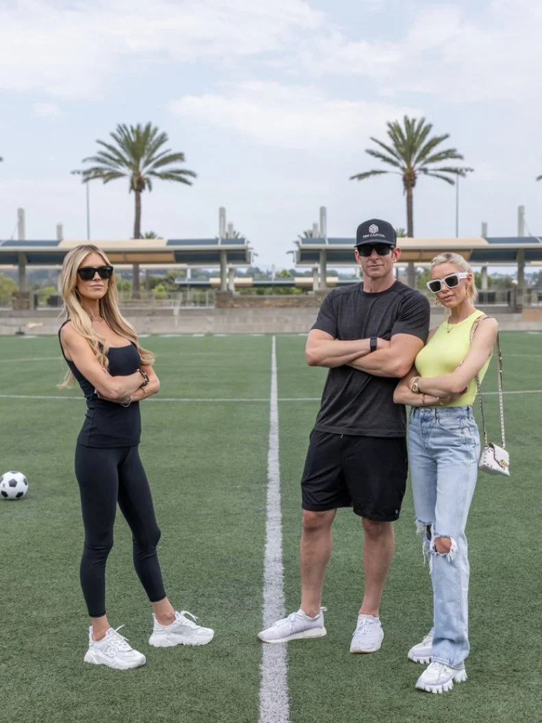 Christina Haack, Tarek El Moussa and Heather El Moussa on the soccer field looking away from camera, as seen on The Flip Off, Season 1.