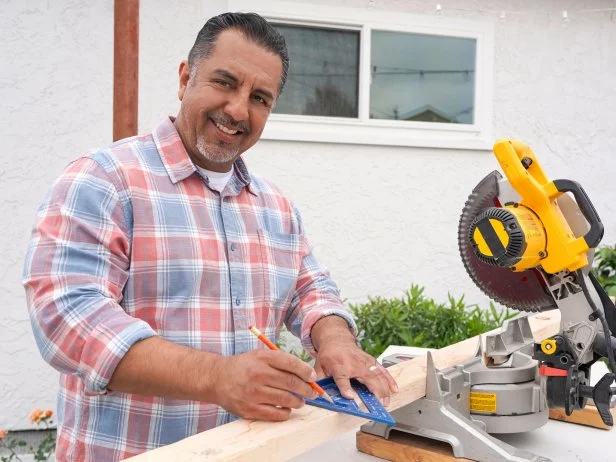 Izzy Battres posing as he measures and cuts wood as seen on the Izzy Does It pilot.