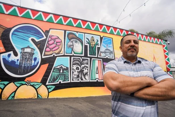 Izzy Battres poses in front of a Santa Ana mural as seen on the Izzy Does it pilot.