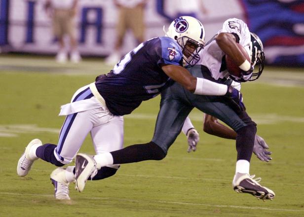 NASHVILLE, UNITED STATES:  Tennessee Titans' DeRon Jenkins takes down Philadelpha Eagles' Todd Pinkston after he caught a pass from Donovan McNabb during their preseason game at Aldelphia Coliseum on 23 August 2001. AFP Photo/NEIL BRAKE (Photo credit should read NEIL BRAKE/AFP/Getty Images)