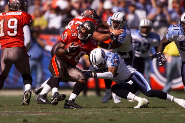 14 Oct 2001: Warrick Dunn #28 of the Tampa Bay Buccaneers is being tackled by DeRon Jenkins of the Tennessee Titans during the game at Adelphia Coliseum in Nashville, Tennessee.  The Titans won in overtime 31-28. DIGITAL IMAGE. Mandatory Credit: Andy Lyons/Allsport