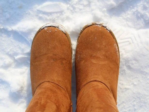 warm brown ugg boots on snow in cold winter