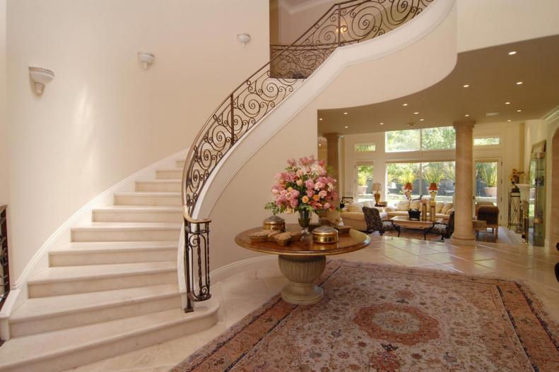 Jerry Rice's Entryway With Marble Stairs, Area Rug & Round Gold Table