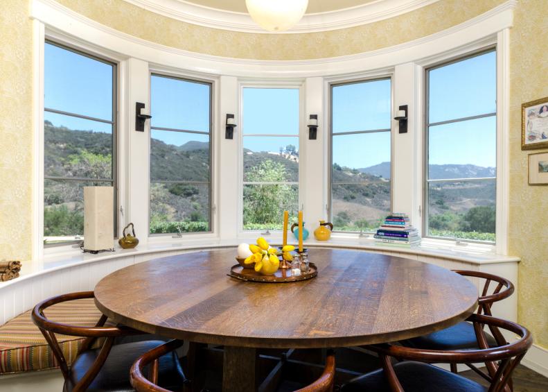 Neutral Dining Room With Round Wood Table & Mountain View