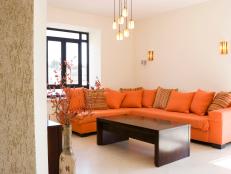 Living Room with Orange Sectional and Dark Brown Coffee Table 