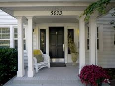 White Covered Porch With Black Front Door