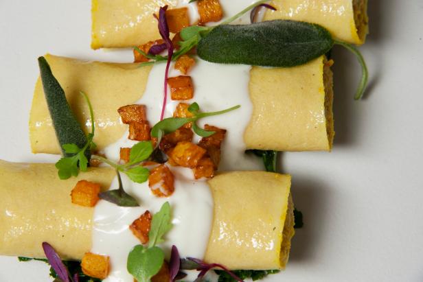 Filled with a mixture of butternut squash, ricotta cheese and sage, these homemade cannelloni sit on a bed of sauteed kale and are garnished with fried sage.