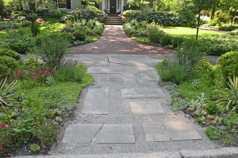 Landscaper Bobbie Schwartz created a memorable entrance to this Ohio home by turning the hellstrip area into drought tolerant gardens separated by a permeable path from the street to the front walkway.&nbsp;