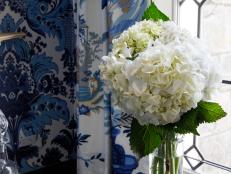 Beautiful arrangements don't have to cost a fortune. You only need a few  lush, white hydrangeas in a tall glass cylinder vase to bring a touch of elegance to any room. And don't  think of flowers just for dining rooms: spread them throughout the house  to offer a surprise in laundry rooms, guest rooms, bathrooms and  entryways.