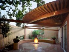 A neutral patio design that incorporates an in-ground fire pit.