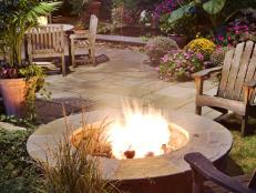 A blazing fire surrounded by flowering plants creates an inviting atmosphere. Design by Robert Hursthouse.