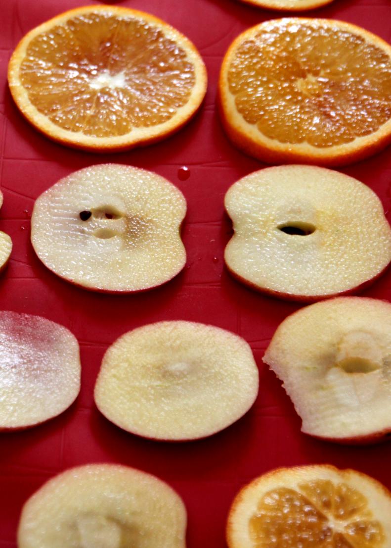Preheat the oven to 200 degrees F. On a baking sheet, arrange thinly sliced apples and oranges. Dehydrate them in the oven for approximately 2 hours.