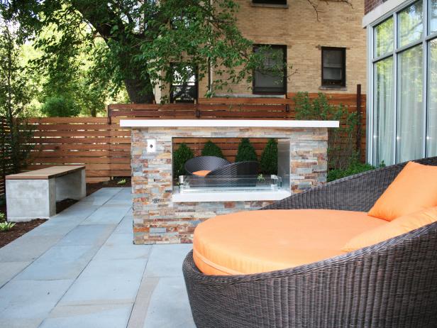 This residential condo building features a blue stone patio, tropical hardwood slat screen fencing, landscaping, custom concrete/tropical hardwood benches, two-sided fireplace, daybed and and lounge chairs.