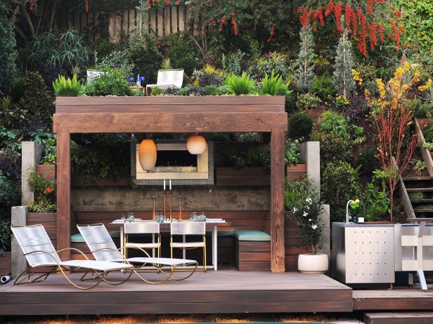 This outdoor dining room features a rooftop garden, and the fireplace and lamps add warmth to the intimate space.