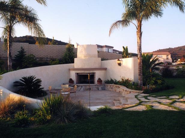 A contemporary Mediterranean-style outdoor room, designed by Bruce Meeks, features the seamless integration of fireplace and wall.