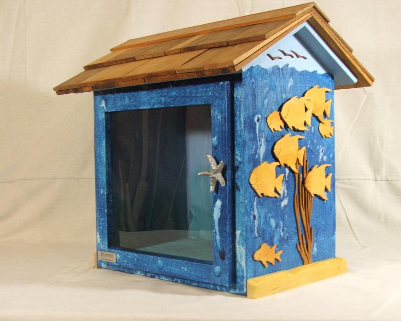 Soothing shades of blue, a playful design of birds and goldfish and a starfish door handle highlight this book house by woodworker Michael Montgomery.