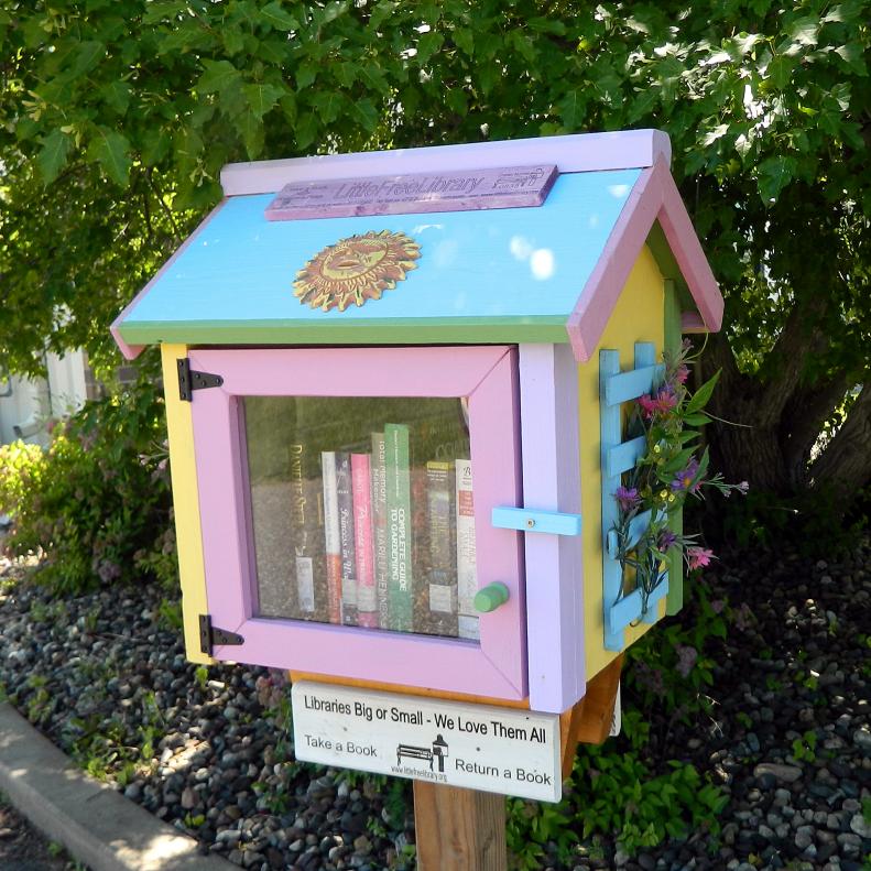 Founded in Wisconsin by Todd Bol and Rick Brooks, the Little Free Library has become an international phenomenon. Little Free Library book houses, many of which are wonderful folk art creations, are springing up around the world in this movement which builds a sense of community and promotes literacy by creating these free book exchanges where readers can donate or take books as desired. This charming pastel colored book house with side trellis was painted and decorated by Elizabeth J. Kennedy.