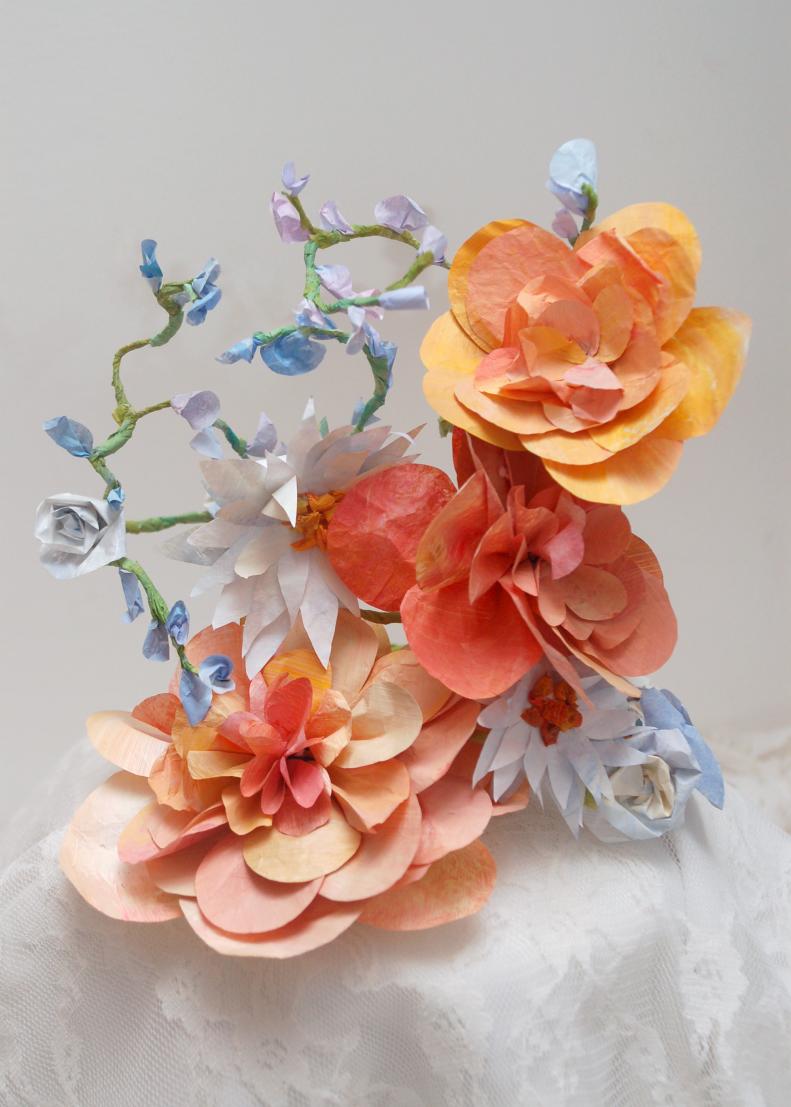 Flowers are almost certainly a huge part of your wedding day, but it is usually difficult if not impossible to keep wedding plants long term. This arrangement of paper flowers makes a beautiful cake topper and it will last for years. Use your personal mix of colors and flowers with the instructions in this gallery to create a unique cake topper for your wedding day.