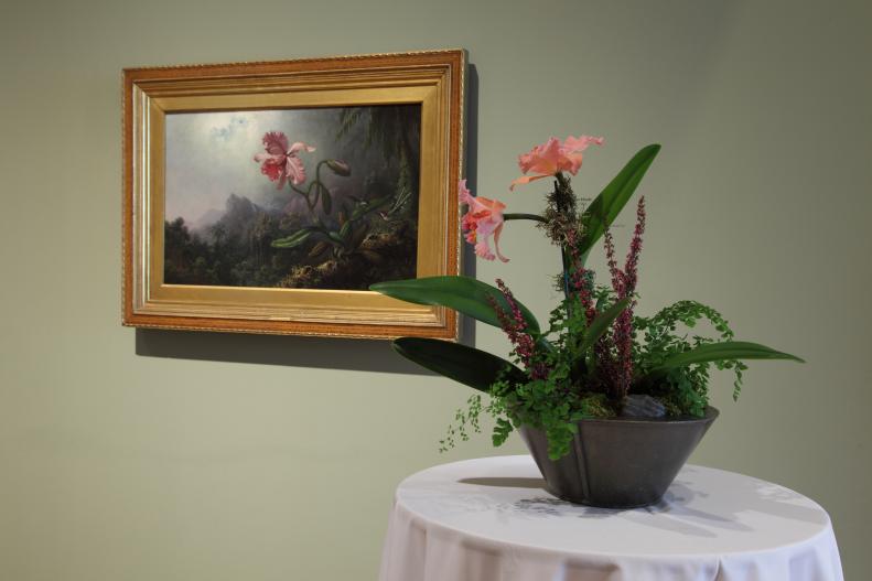 The elegance of <i>Two Hummingbirds with an Orchid, </i>painted by Martin Johnson Heade, was Peachtree Garden Club's inspiration for their floral arrangement. It included cattleya orchid, heather, <a target="_self" href="http://www.hgtvgardens.com/flowers-and-plants/american-maidenhair-fern-adiantum-pedatum">maidenhair fern</a>, sphagnum moss, and spanish moss.