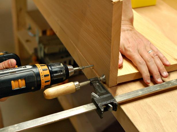 After gluing one part of window box to the other, hold with a clamp, and then use drill to screw pieces together for added strength and durability.