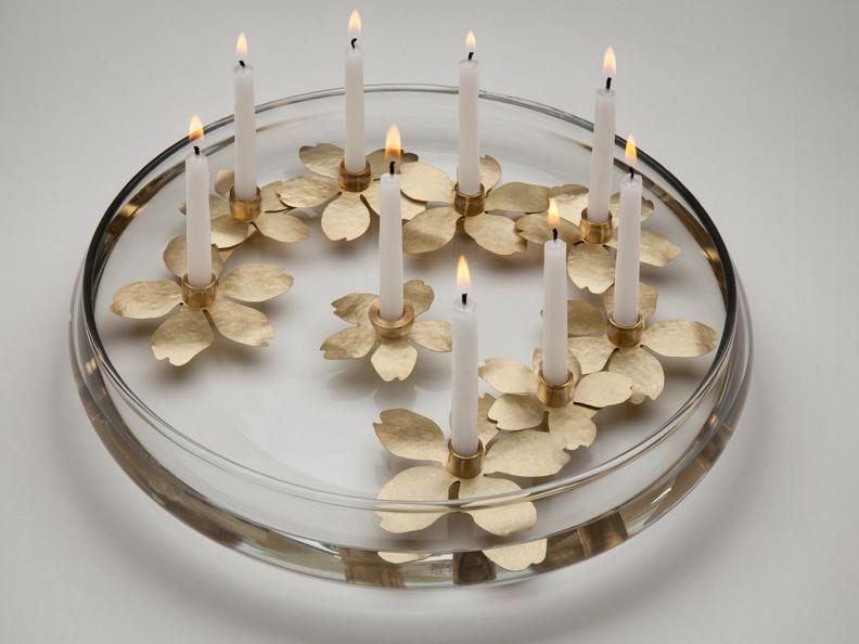 A ring of almond blossoms creates an enchanting Hanukkah centerpiece, with the lights reflected in the shallow pool of water. Judiaca artisan  Amy Reichert's <a target="_blank" href="http://shop.thejewishmuseum.org/Water-Blossom-Menorah-by-Amy-Reichert/PAMDICPGBLHLNGMJ/Product">Water Blossom Menorah</a> is tied to Jewish tradition that the original temple menorah was made of gold, almond-blossom-shaped cups.