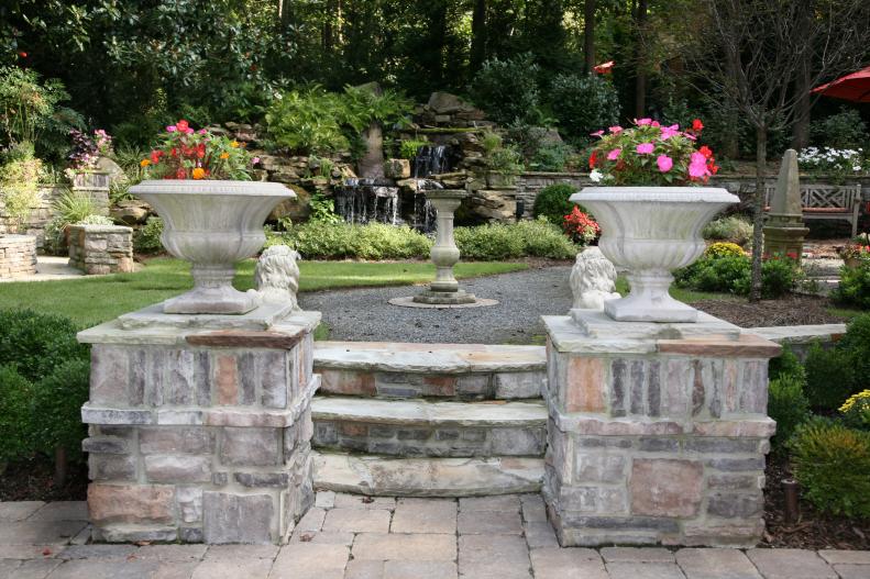 The steps and layout were inspired by Newstead Farm (owned by the Firestone family) in Virginia. The homeowners wanted to evoke a romantic feel, from the fragrant flowers to the waterfall. They incorporated stone from south Georgia and antique English-style lawn ornaments.