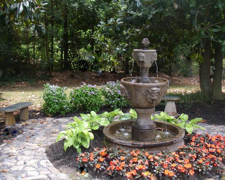 In redoing a client's garden, landscape architect Danna Cain of <a target="_blank" href="http://www.homegardendesign.com">Home &amp; Garden Design</a> found the fountains and benches on clearance. She repurposed stone from a previous project in the yard, with mini garden pebbles added in between. Hosta, <a target="_blank" href="/flowers-and-plants/new-guinea-impatiens-impatiens-x-hawkeri">New Guinea Impatiens</a> and lacecap hydrangeas surround the fountain and stone pathway.