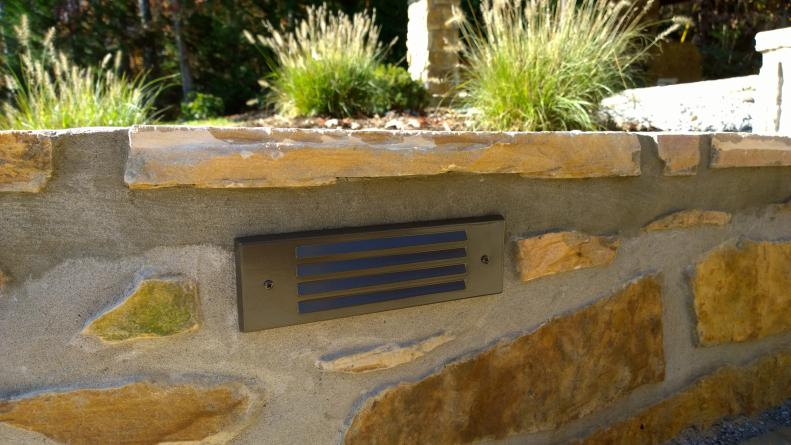 Insert low-voltage landscape lighting into a retaining wall, to make pathways more safe and to bring a glow to your outdoor space. It can be a DIY project, using a landscape lighting kit, or you can work with an expert, such as a landscape designer or lighting company.