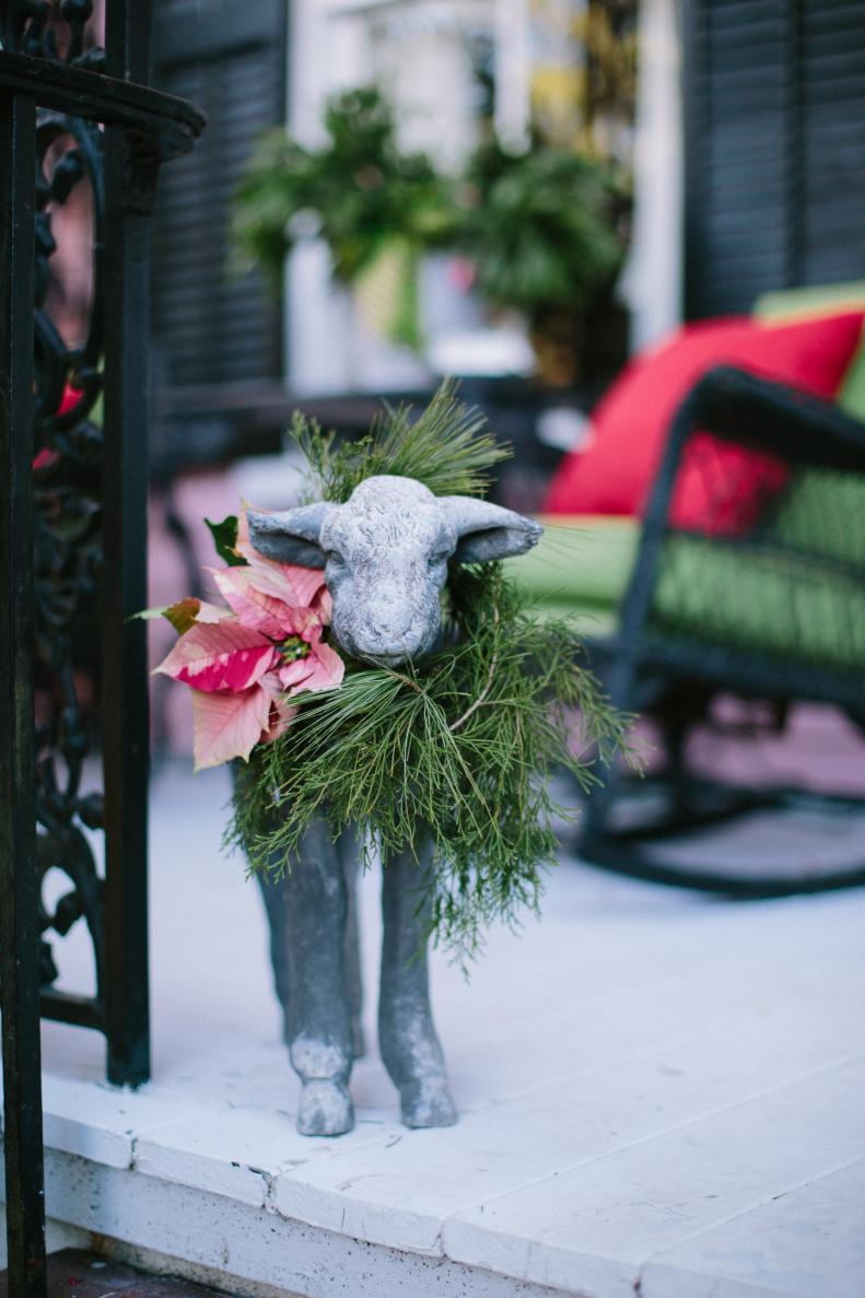 Dressing up the statuary on the porch adds a festive touch for the holiday season. This lamb's poinsettia collar fits perfectly with the sprawling porch's Christmas decor. Styled by <a target="_blank" href="http://www.cotedesignsevents.com/#!/HOME">Cote Designs</a>.