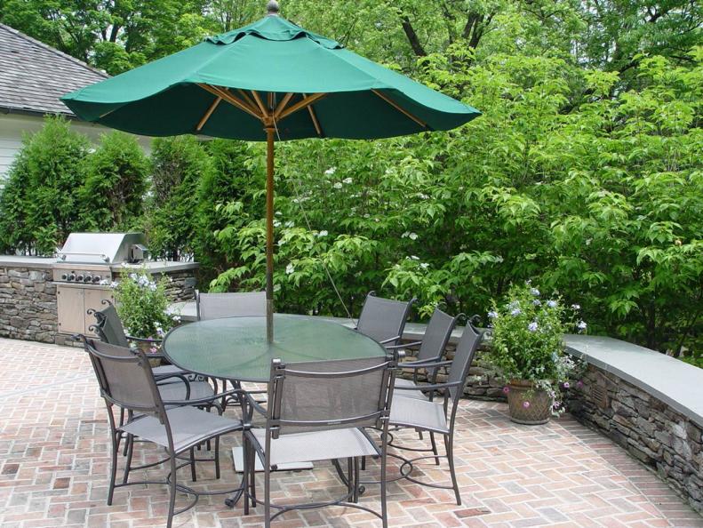 Using a simple curved line can be evocative when designing the shape of an outdoor living room. This patio space designed by <a target="_blank" href="http://www.johnsenandscapes.com">Johnsen Landscapes &amp; Pools </a>also has other key elements, including a dining table with umbrella, built-in grill and planters.
