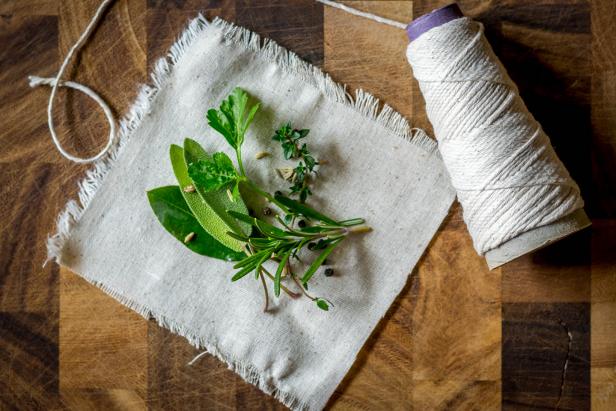 Cloth, Spool of Cotton Twine, and Fresh Herbs