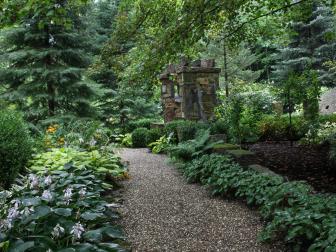 A gravel path winds around to a massive stone arch in the entryway to the &quot;Sun and Moon Garden&quot; in Ohio. Designed by <a target="_blank" href="http://www.miriamsriverhousedesigns.com/">Miriam's River House Designs</a>, the garden and walkway won a 2014 Association of Professional Landscape Designers award.