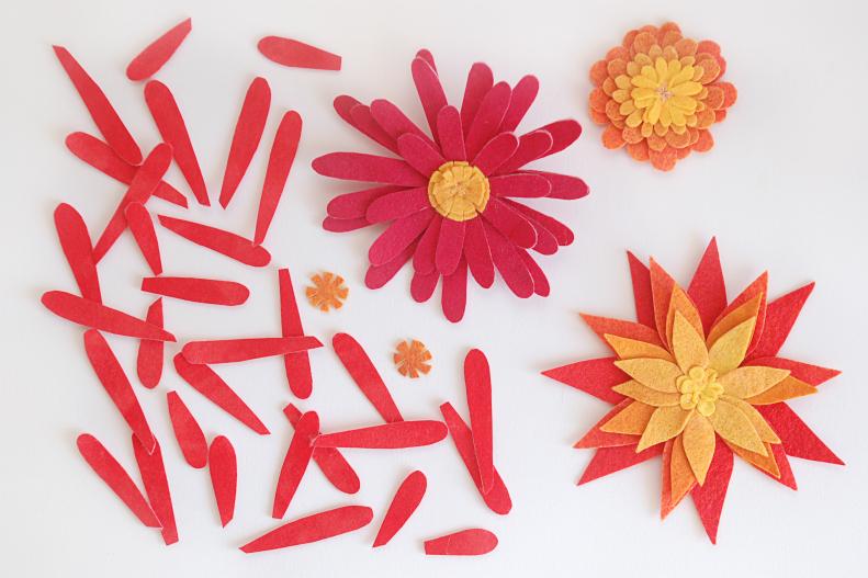 The simplest felt flowers are made by arranging petal shapes in a circle. You can make daisies, poinsettias, dandelions and many more this way. Simply choose a petal shape, rounded or pointy, narrow or wide, and cut it out in a variety of sizes. You want some of your petals to be long and some to be short.