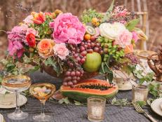 Filled to the brim with flowers and fruits, this autumn centerpiece from <a target="_blank" href="http://www.cedarwoodweddings.com/">Cedarwood Weddings</a> overflows with peonies, tulips, ranunculus, pink Majolica roses,  heather, blizzard roses, ivy, privet berries, euphorbia, Berzillia berries and edibles including  kumquats, kiwi fruit, grapes, papaya and green apples.