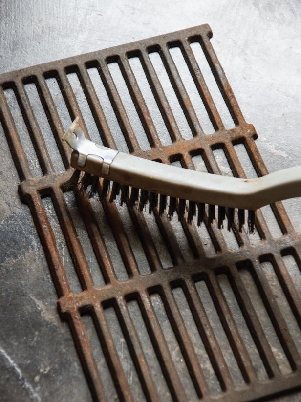With a stiff wire brush and steel wool, remove any rust and build up from the grates. Wash in warm soapy water and dry completely. Coat the grates with a thin layer of cooking oil.