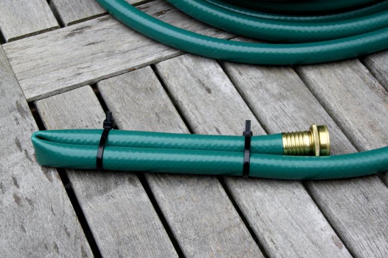 Begin by folding one end of the hose on itself and zip tie it together as shown. The length is approximately 8 inches.