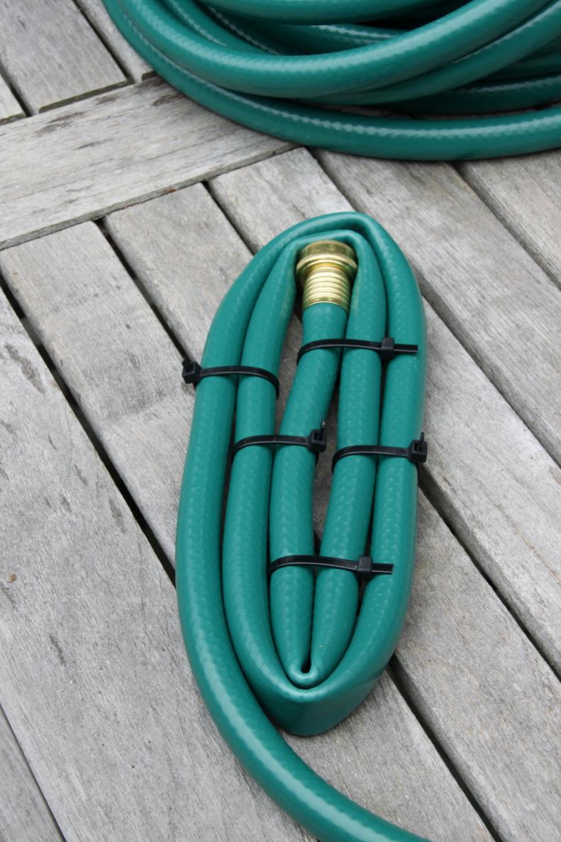 Being to coil the hose and zip tie it together at regular intervals to form the base of the basket. Once secure clip off the excess from each zip tie.