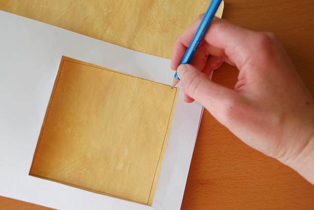 Once the inside of your card is finished, place a colored piece of paper inside and trace the shape of the window again. Use this guideline to create a frame for your window. Cut the window shape out of the paper, leaving a frame the size of your choice intact around it.