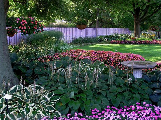 Planting trees, with shade loving shrubs, perennials, groundcovers, and  especially a &quot;hard&quot; accent such as this birdbath, frame the garden and  make the lawn seem neater.