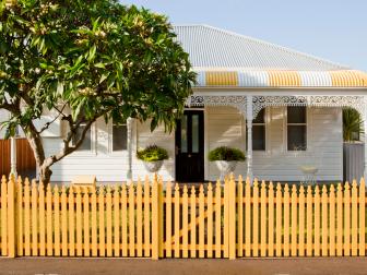 A Victorian style cottage with a timber picket fence in Australia is given a contemporary look and feel with a strong yellow and white color theme by Horton and Co.