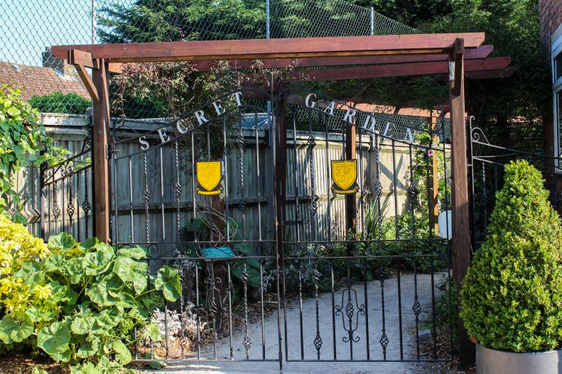 An elegant metal gate keeps the schoolyard garden secure when not in use.